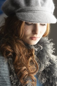 Fashionable Teenage Girl Wearing Cap And Knitwear In Studio